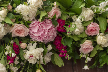 Wedding flowers decoration on brown wooden fence.