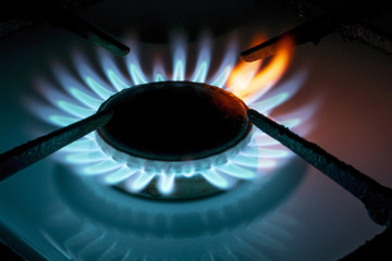 burning gas burner in the dark, close-up with a red flame tongue