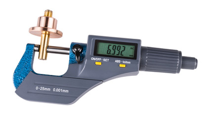 Digital micrometer and shiny metal workpiece. Close-up of measuring a bronze and brass metallic...