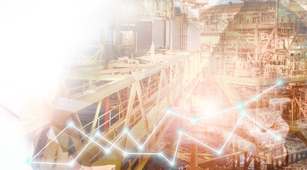 Double exposure of hand using tablet with offshore oil and gas platform background with stock trading graph for oil and gas business industry concept