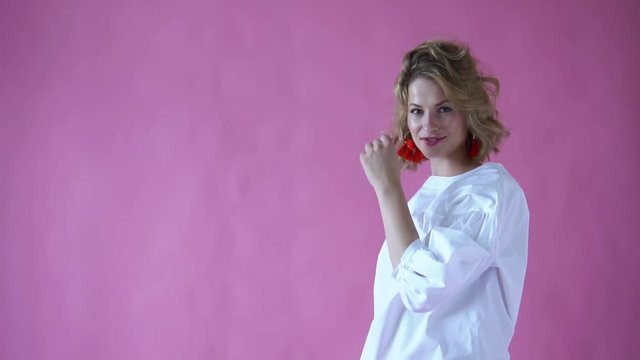 cheerful positive blonde girl posing for the camera in a photo Studio on a pink background