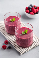 Mixed berry smoothie with mint on light concrete background