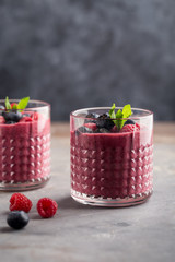 Mixed berry smoothie with mint on light concrete background, close up