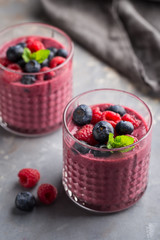 Mixed berry smoothie with mint on concrete background, close up