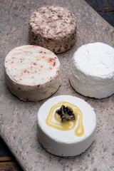 French soft cheeses, variety of different taste goat milk natural cheeses on granite plate close up sesrved as dessert