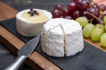French soft cheeses, variety of different taste goat milk natural cheeses on granite plate close up sesrved as dessert