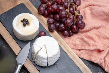 French soft cheeses, variety of different taste goat milk natural cheeses on granite plate close up sesrved as dessert