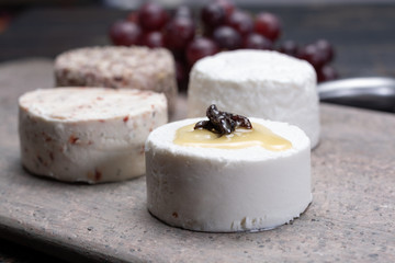 French soft cheeses, variety of different taste goat milk natural cheeses on granite plate close up sesrved as dessert