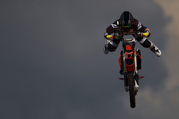 Professional rider at the FMX make an acrobatic jump at the motor show. Motorcycle in the air