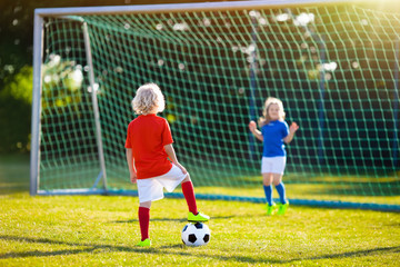 Kids play football. Child at soccer field.