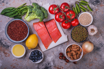 Fresh  fish, vegetables, fruits, nuts on grey stone   background, top view.  Ingredients for healthy cooking. Healthy food concept.