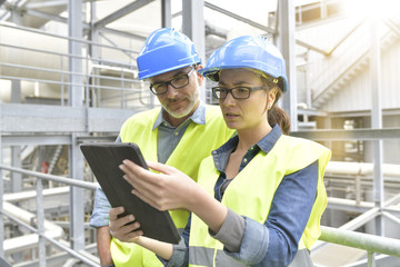 Industrial engineers working in recycling plant with tablet