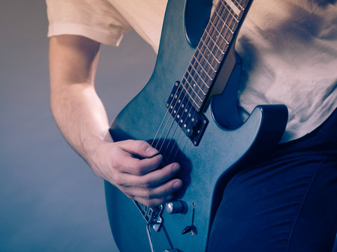 Close up of man playing on electric guitar