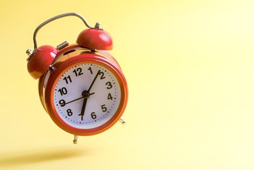 Red alarm clock jumping