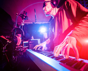 Obraz na płótnie Canvas Young man playing piano in sound recording studio.