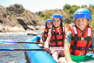Little children kayaking on river. Summer camp
