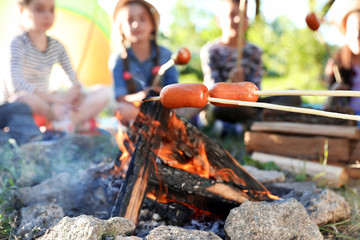 Fototapeta premium Frying sausages on bonfire, closeup. Summer camp
