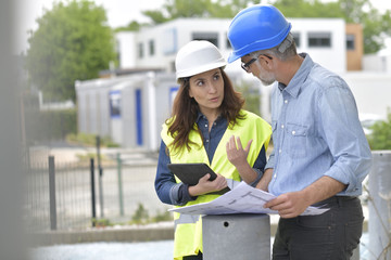 Construction engineers meeting outside building