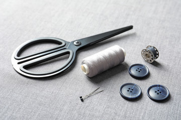 Set of tailoring accessories on grey fabric