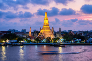 The boat was sailing in Chao Phraya River, background Wat Arun at sunset time ,Bangkok, Thailand. The Temple of Dawn