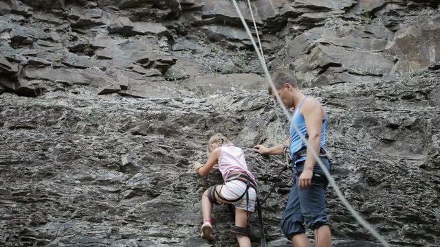 Young man with daughter on a rock climbing