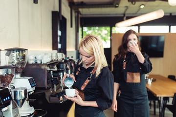 Procedure of making fresh coffee. Professional baristas pouring milk into cup of espresso coffee.
