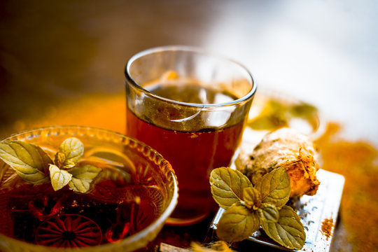 Close up of Ayurvedic home remedy for common cold: Fresh organic ginger ( grated) , warm water, cinnamon stick, honey, and lemon juice.