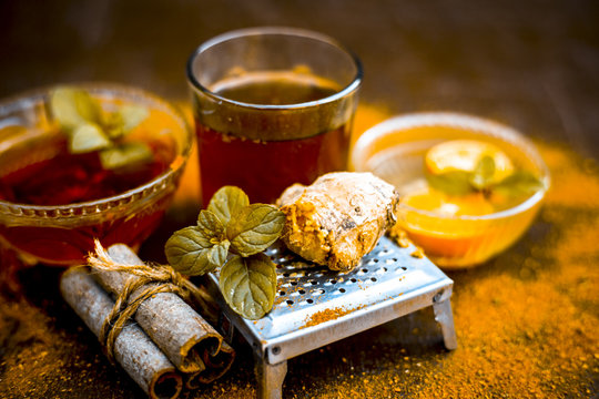 Close up of Ayurvedic home remedy for common cold: Fresh organic ginger ( grated) , warm water, cinnamon stick, honey, and lemon juice.