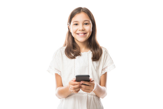Portrait of a smiling latin girl using smartphone isolated on a white background