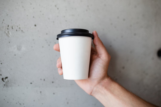 Barista holding cup of coffee to go.