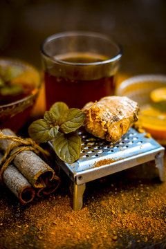 Close up of Ayurvedic home remedy for common cold: Fresh organic ginger ( grated) , warm water, cinnamon stick, honey, and lemon juice.