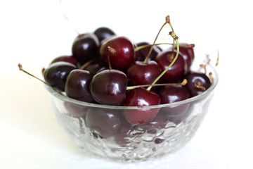 cherry fruit in glass bowl on white background.