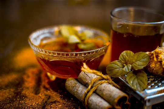 Close up of Ayurvedic home remedy for common cold: Fresh organic ginger ( grated) , warm water, cinnamon stick, honey, and lemon juice.