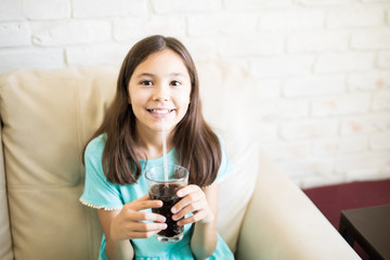 Beautiful girl drinking a black soft drink