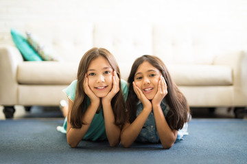 Happy little kids lying on carpet