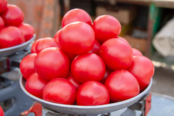 Pink fresh tomatoes, laid out on the scales by the seller on the market. Farmer's vegetable market in Kiev, Ukraine