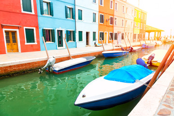 Fototapeta na wymiar Colorful houses and boats in Burano island with sunlight near Venice, Italy. Popular and famous tourist place