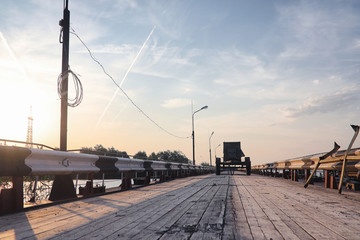 Wooden bridge on the river bank. A wooden road with pillars. Pan