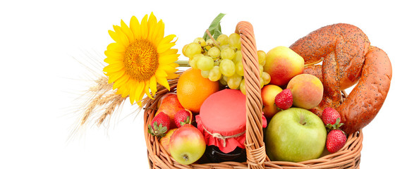 A set of fruits and pastries in a woven basket isolated on white background. Wide photo. Free space for text.