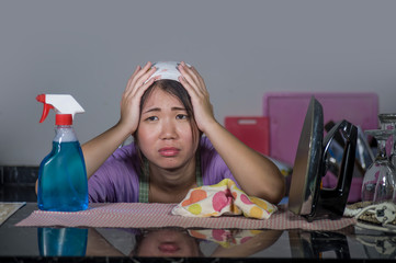 young pretty overworked and stressed Asian Korean service maid woman working domestic cleaning and washing with spray bottle angry and upset