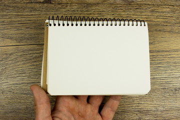 Obraz premium Male hand holding notebook. Empty space for design and text. 