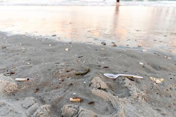 plastic spoon and cigarettes on the beach