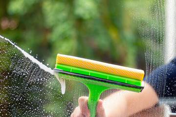 Window cleaner using a squeegee to wash a window