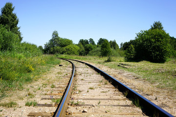 Obraz premium Curving rail line winds its way through trees and forests.