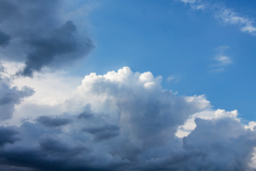 White cloud in the gloomy sky surrounded by dark clouds_