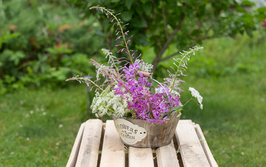 букет цветов на деревянном ящике в  летнем саду на зеленой траве