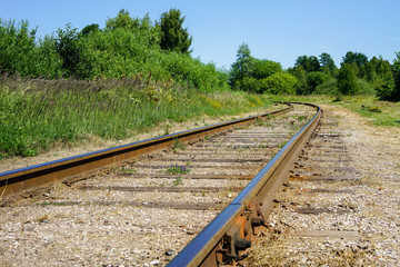 Curving rail line winds its way through trees and forests.