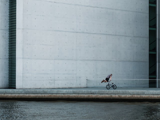Young man riding bmx bike, making tricks with bicycle -