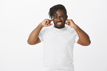 Turn off volume. Portrait of bothered displeased attractive plump guy with dark skin, frowning and...