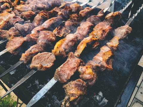 Mcvadi - shashlik preparing on a barbecue grill over charcoal. Roasted stacked meat traditional cuisine in Georgia